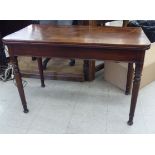 A Regency mahogany tea table, the foldover top on a rear gateleg action, raised on ring turned,