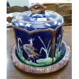 A late 19thC majolica green, brown, pink and blue glazed cheese dome and dish,