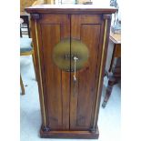 A modern Chinese inspired stained pine cabinet, the pair of full height doors with iron fittings,