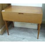 A late 1960/70s teak sewing box with a hinged lid, enclosing a tray fitted interior,