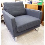 A charcoal coloured fabric upholstered office reception easy chair, raised on a chromium plated,