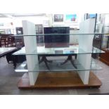 A modern, partially glazed, two sided, three tier buffet, elevated on a faux mahogany,