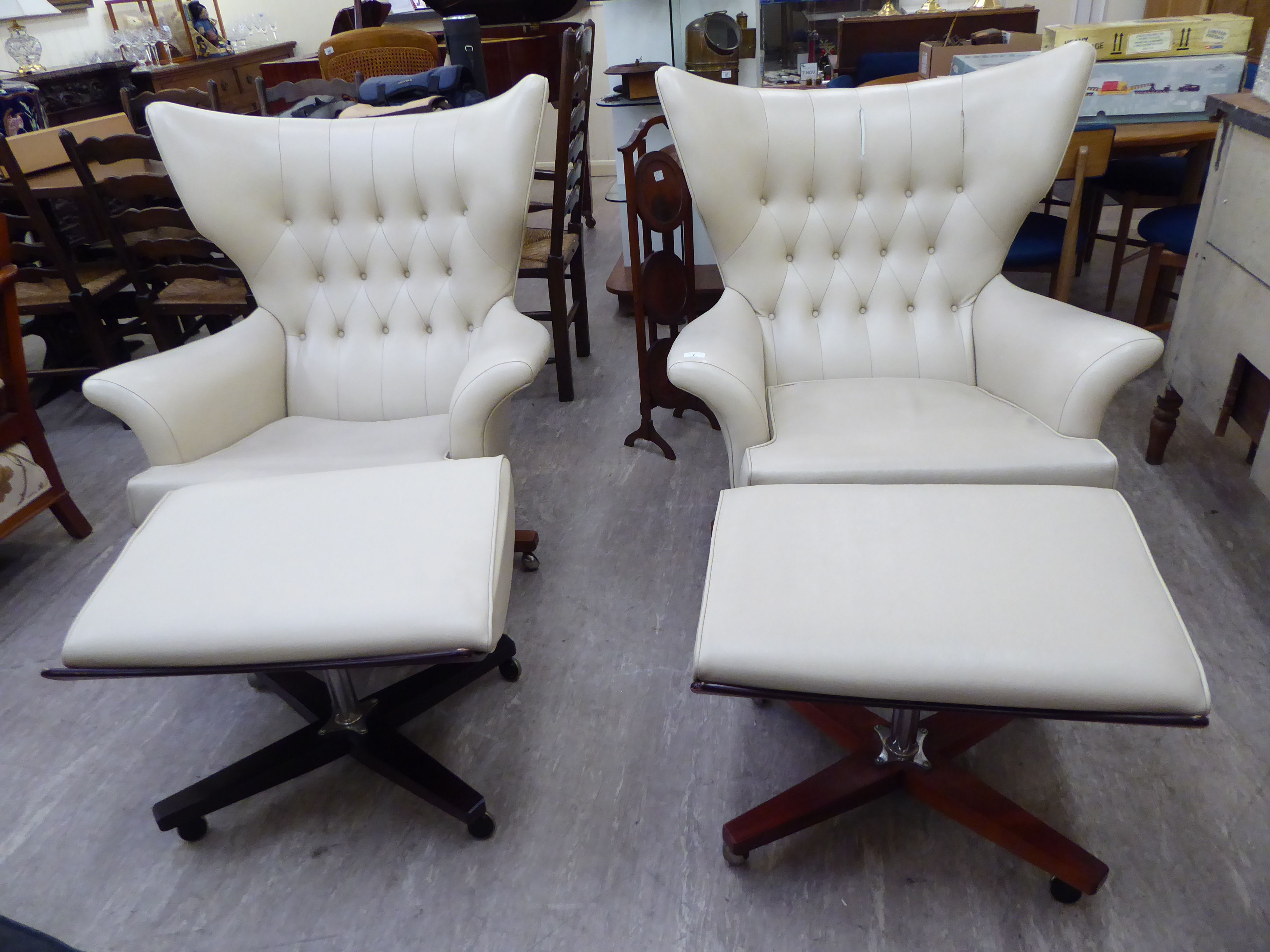 A pair of G-Plan rosewood framed, cream coloured hide, button upholstered easy chairs,