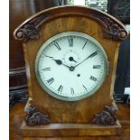 A late 19thC carved and figured mahogany cased mantel timepiece with a round arched top and