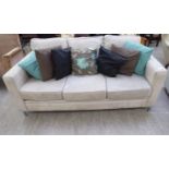 A modern cream coloured suede upholstered, low level backed, three person settee,