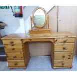 A modern waxed pine, twin pedestal, eight drawer dressing table, on a plinth,