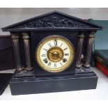 A late Victorian black slate mantel clock of architectural form;