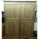 An early 20thC waxed pine two part larder cupboard, comprising two pairs of panelled doors,