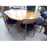 A G-Plan teak extending dining table, the top with a crossbanded border, raised on turned,