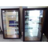 A pair of modern stained pine hanging display cabinets, the hinged,