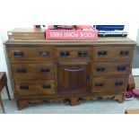 An early 20thC walnut sideboard, comprising an arrangement of seven drawers,