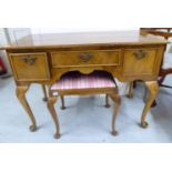 A mid 20thC crossbanded and figured walnut, three drawer kneehole dressing table,