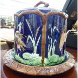 A late 19thC majolica green, brown, pink and blue glazed cheese dome and dish,