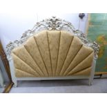 A modern cream coloured painted French inspired C-scrolled and floral carved headboard with an old