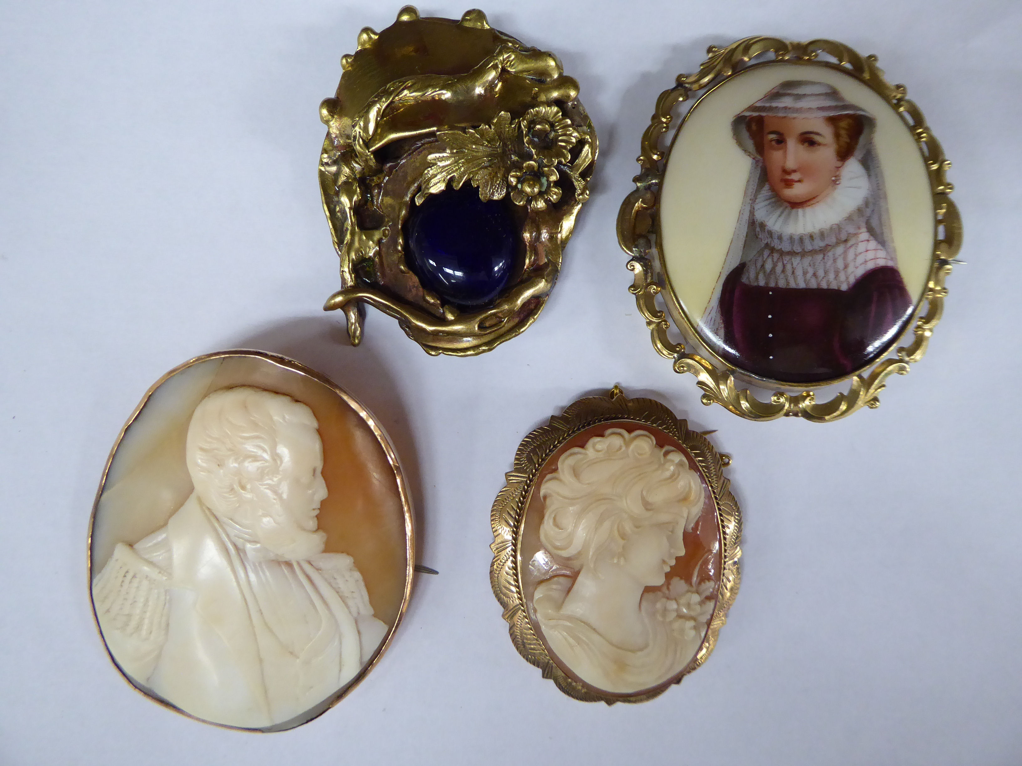 Four dissimilar 9ct gold and yellow metal variously set cameo brooches 11