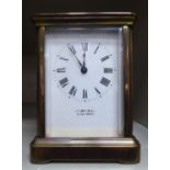 A mid 20thC miniature carriage timepiece with bevelled glass panels, a folding top handle,