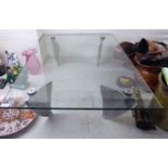 WITHDRAWN A modern coffee table, the glass top raised on chromium plated,