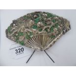A Chinese silver coloured metal, part green enamelled fan ornament, on an easel stand,