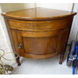 An early 20thC mahogany low quadrant corner unit with a panelled door, raised on ring turned,