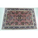 A Persian design rug, decorated with stylised flora, bordered by additional foliage,