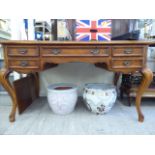 A modern Louis XV design mahogany finished desk with five graduated drawers,