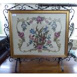 A modern cast iron firescreen, set with a floral tapestry panel,