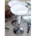 A pair of white painted height adjustable bar stools,