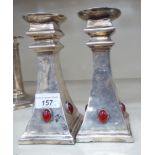 In the manner of Liberty, a pair of Arts & Crafts silver plated candlesticks,
