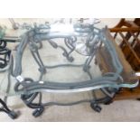 A modern black painted wrought iron lamp table, the glass top with serpentine front edge,