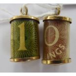 Two 9ct gold mounted cylindrical pendants, one containing a rolled £10 note,