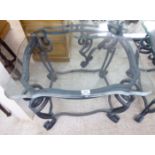 A modern black painted wrought iron lamp table, the glass top with serpentine front edge,