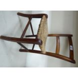 A late Victorian doll's stained beech bar back chair with a woven rush seat,