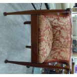 An early 20thC mahogany showwood framed, tub style chair with a low, level back,