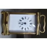 A mid 20thC lacquered brass cased serpentine outlined carriage timepiece with bevelled glass panels