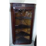 A George III mahogany corner cupboard with a glazed door, enclosing three shelves,