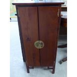 A modern Chinese inspired mahogany CD cabinet with a pair of doors, enclosing four shelves,
