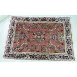 A Persian rug, decorated with stylised flora, bordered by additional foliage,