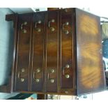 A modern crossbanded walnut and mahogany bureau with a fall-flap, over four drawers,
