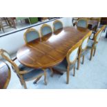 A modern Regency style yewwood finished dining table, the oval top with an additional leaf,