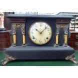 A late Victorian black painted wooden cased mantel clock of architectural form;