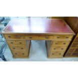 An early 20thC light oak nine drawer, twin pedestal desk,