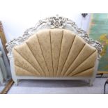 A modern cream coloured painted French inspired C-scrolled and floral carved headboard with an old