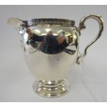 A silver cream jug of ovoid form with a C-scrolled handle,