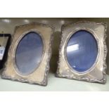 A pair of Edwardian glazed silver photograph frames with oval apertures,