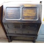 A 1920/30s Old English style stained oak bureau with a fall-flap, over two drawers,