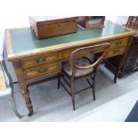 An Edwardian style stained oak five drawer kneehole desk, raised on bulbous, reeded,