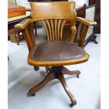 An early 20thC beech framed splat back open arm desk chair,
