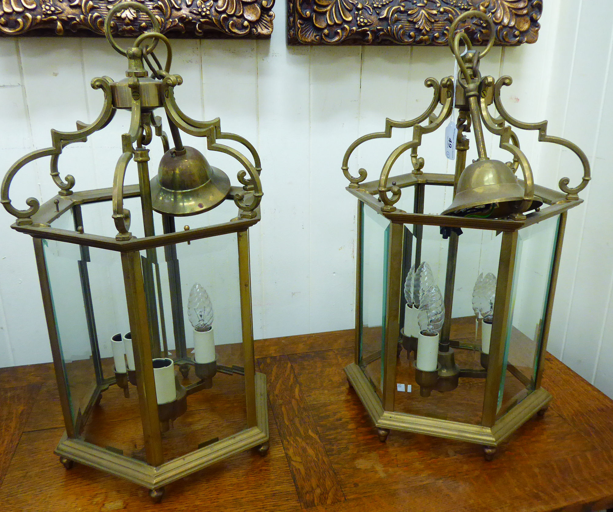 A pair of modern Georgian style lacquered brass framed hexagonal hanging lanterns with glass panels