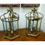 A pair of modern Georgian style lacquered brass framed hexagonal hanging lanterns with glass panels