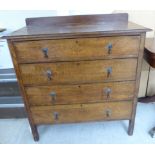 An early 20thC light oak four drawer dressing chest,